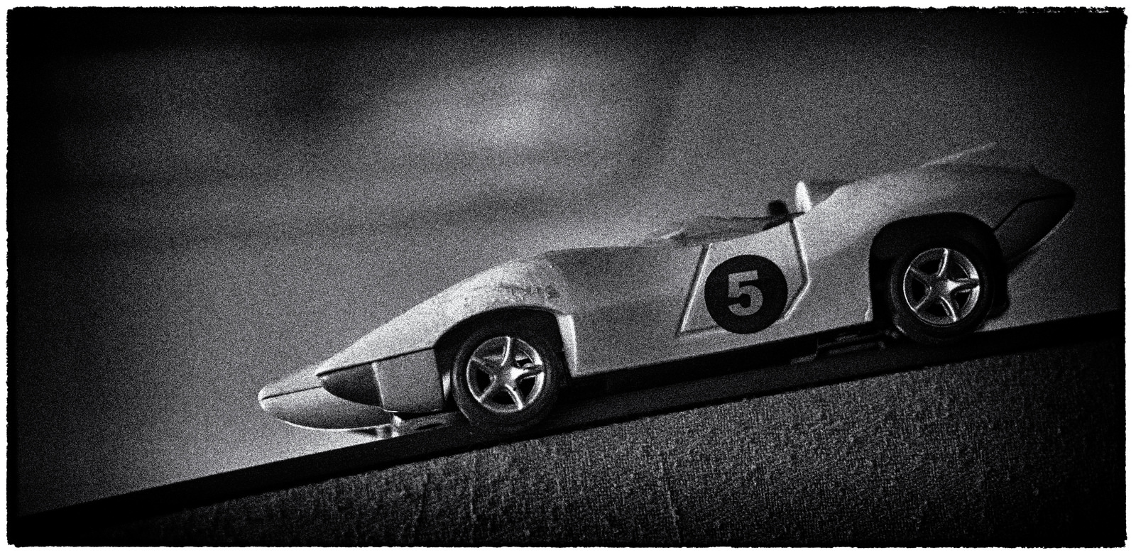 Black and white photo of a vintage toy race car.
