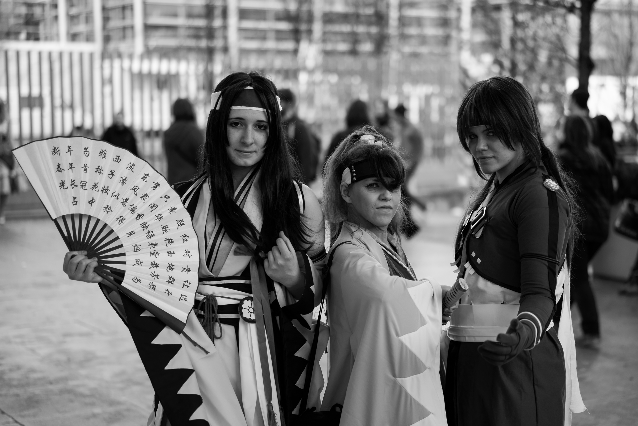Three teenage girls pose in samurai cosplay outfits.